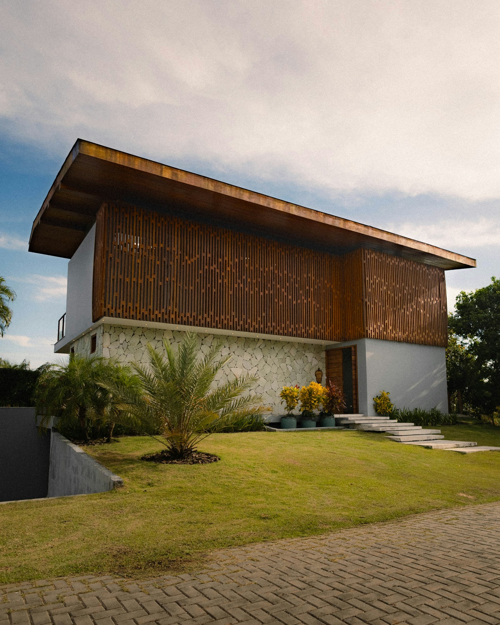 A modern house with timber screening opening toward a garden